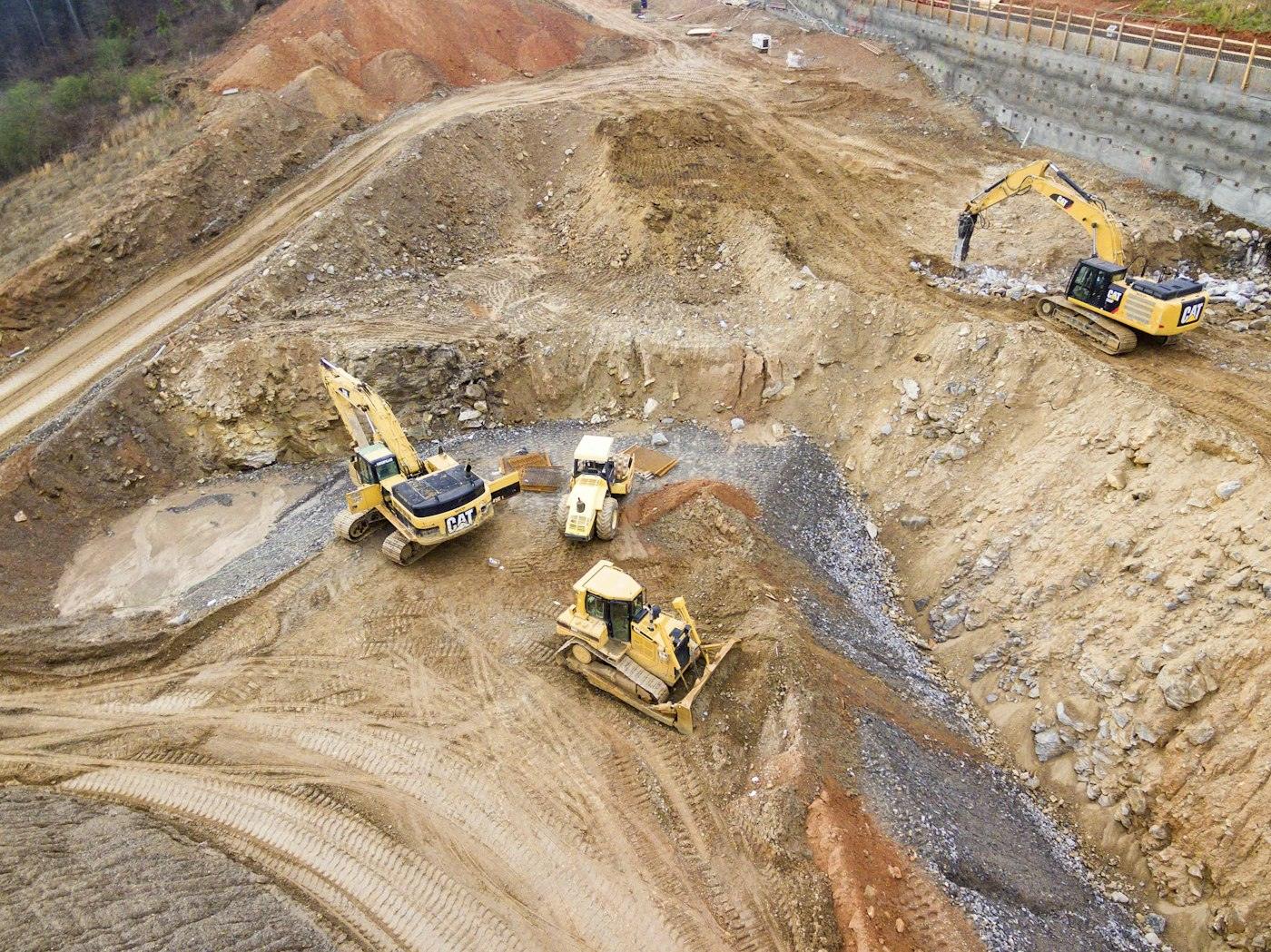 Excavators and bulldozers grading a large construction site